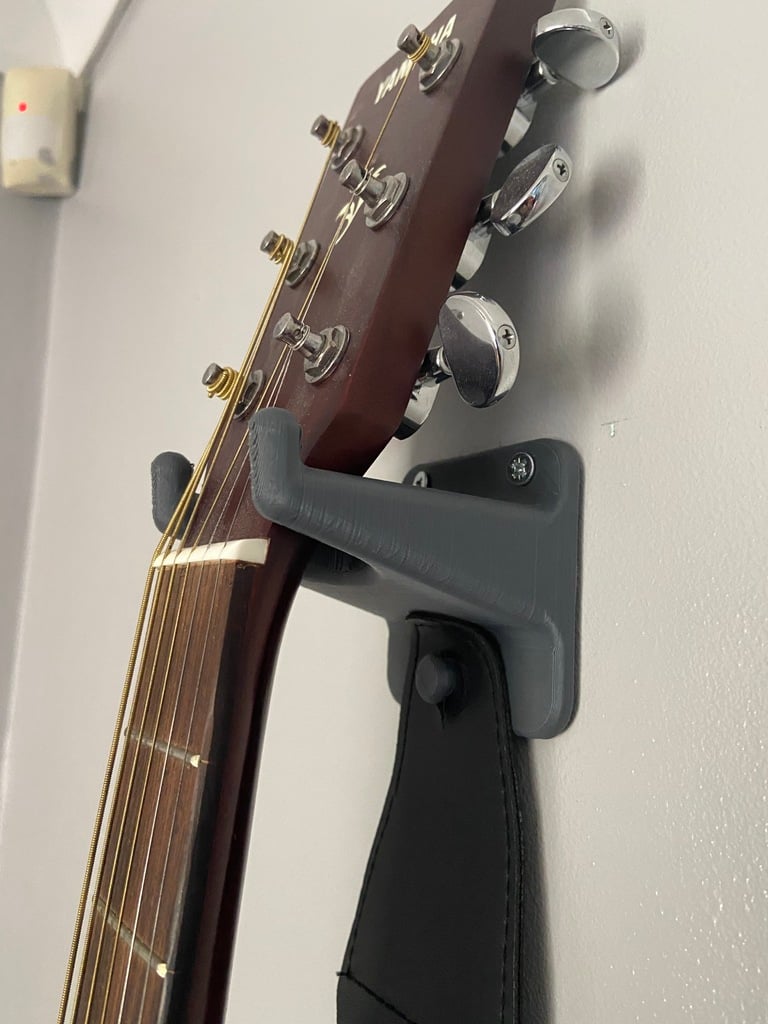Nástěnná montáž kytary s prostorem pro trsátka a popruh