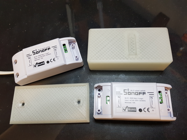Základní krabice Sonoff s ovládacím tlačítkem a otvory pro šrouby